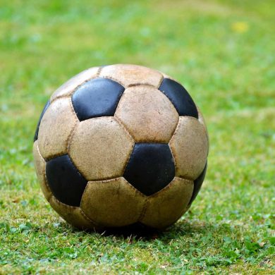 Old-style-football on the green pitch (Photo: Capri23auto on Pixabay).