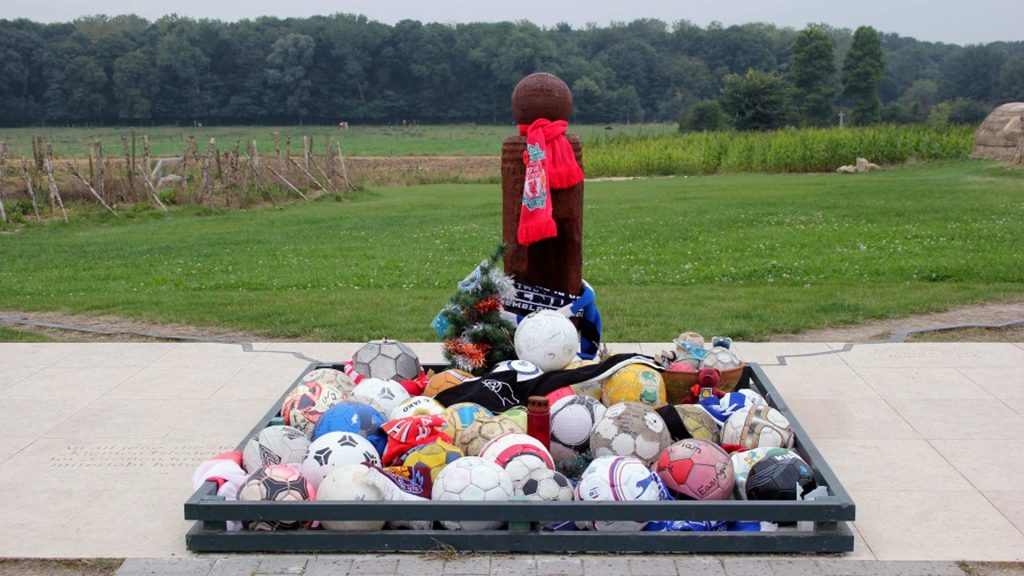 Wooden cross marked with footballs at Truce site.