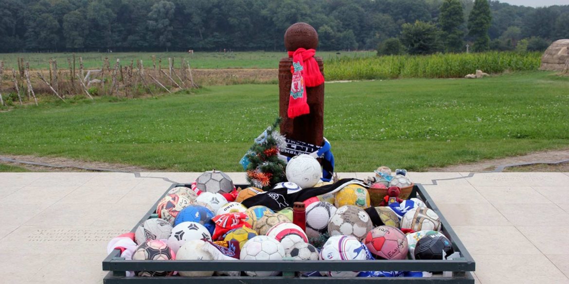 Wooden cross marked with footballs at Truce site.