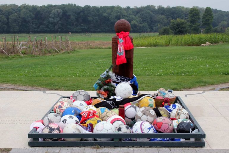 Wooden cross marked with footballs at Truce site.