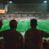 2 fans watching match.