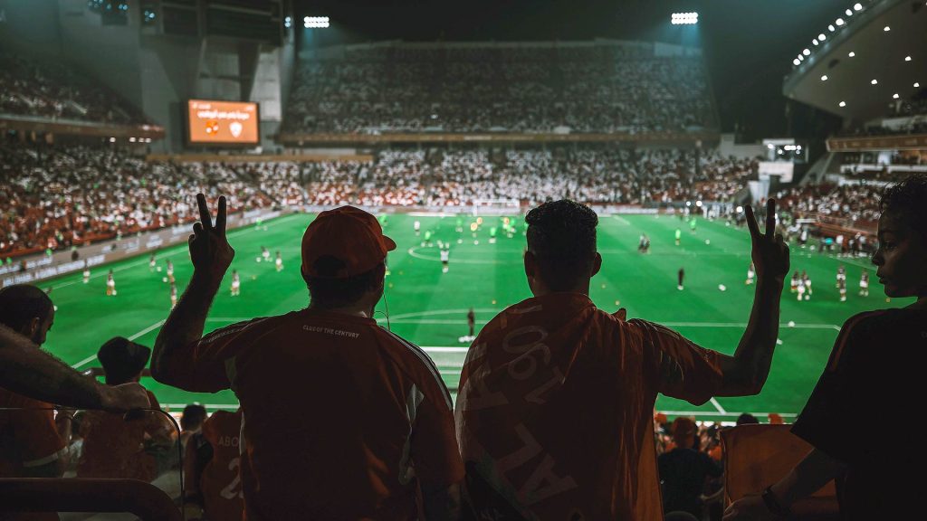 2 fans watching match.
