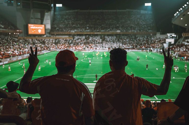 2 fans watching match.